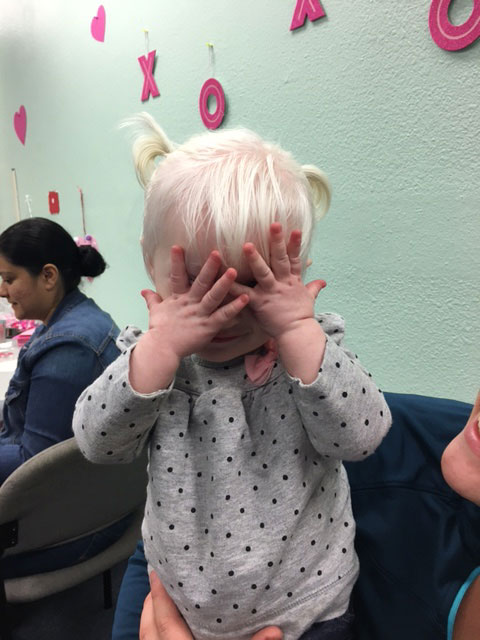 A child is playing peek-a-boo